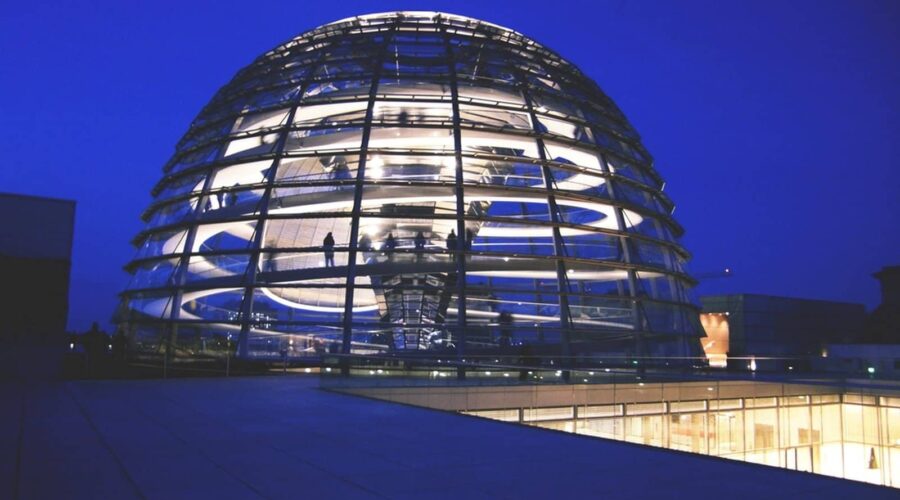 Beleuchtete Glaskuppel des Reichstagsgebäudes bei Nacht – Symbolbild für das deutsche NIS2-Umsetzungsgesetz